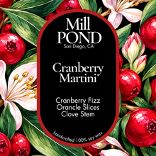 Load image into Gallery viewer, A square product label for Mill Pond Candle Co. Cranberry Martini scented soy wax candle, featuring a black background with white text and a red border, surrounded by a watercolor-style botanical border of red cranberries, green leaves, and white flowers.