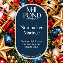 Load image into Gallery viewer, “Dark blue candle label reading Nutcracker Matinee, surrounded by nutcracker figures, gold and red ornaments, blue baubles, and golden stars.”
