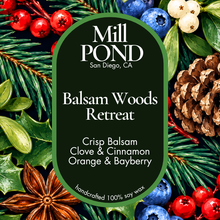 Load image into Gallery viewer, A square product graphic for Mill Pond 'Balsam Woods Retreat' soy wax. The center features a dark green rounded-rectangle label with white text, surrounded by a festive flat-lay of pine needles, pinecones, blueberries, red berries, holly leaves, and star anise.
