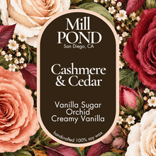 Load image into Gallery viewer, “Brown candle label reading Cashmere &amp; Cedar, surrounded by cream, peach, and deep red roses with green leaves.”
