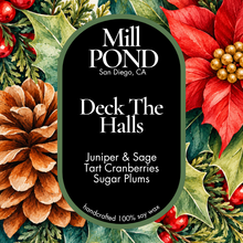 Load image into Gallery viewer, “Holiday candle label with black background and green border, surrounded by pinecones, holly leaves, red berries, and a red poinsettia. Center text reads ‘Mill POND San Diego, CA’ and ‘Deck The Halls’ with scent notes Juniper &amp; Sage, Tart Cranberries, and Sugar Plums. Includes ‘handcrafted 100% soy wax’ at the bottom.”
