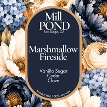 Load image into Gallery viewer, “Navy candle label reading Marshmallow Fireside, surrounded by cream, blue, and brown flowers.”
