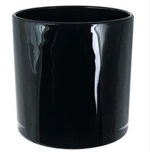 Load image into Gallery viewer, a black cylindrical candle with white wax and two wicks against a plain white background.”
