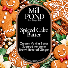 Load image into Gallery viewer, “Black candle label reading Spiced Cake Batter, surrounded by gingerbread cookies, cinnamon sticks, pinecones, holly leaves, and white flowers.”
